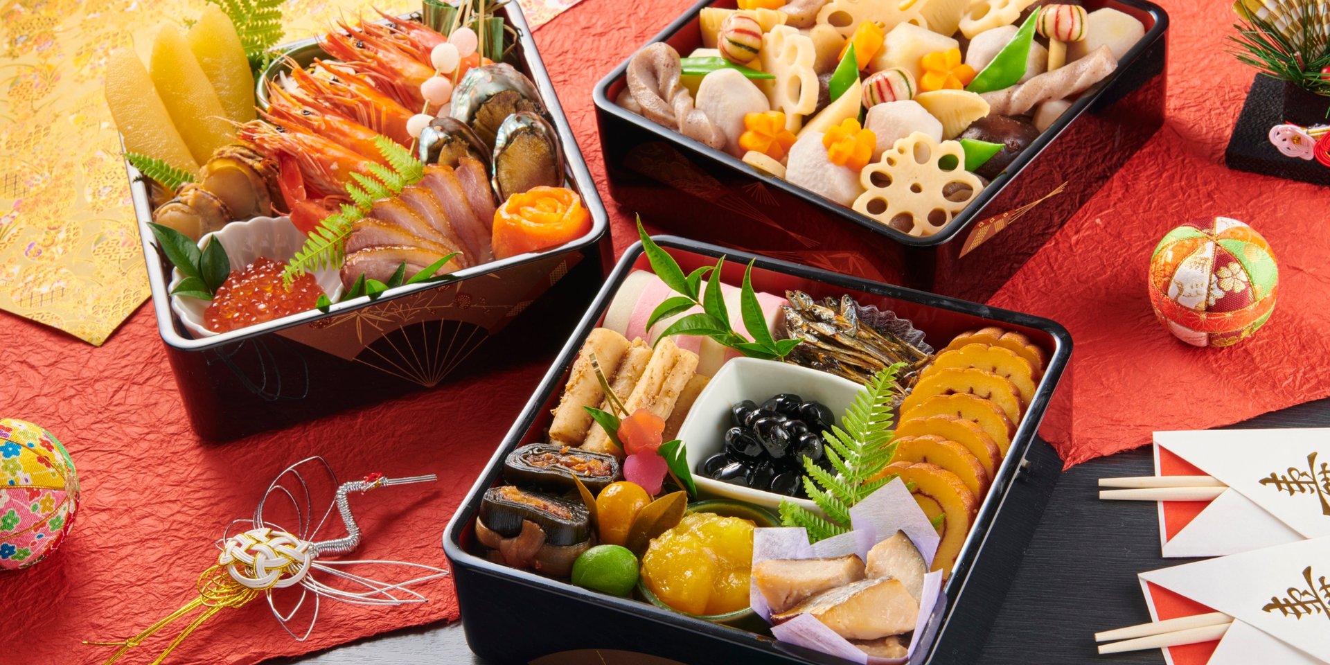 Traditional Japanese Osechi Ryori New Year food served in tiered lacquered bento boxes.