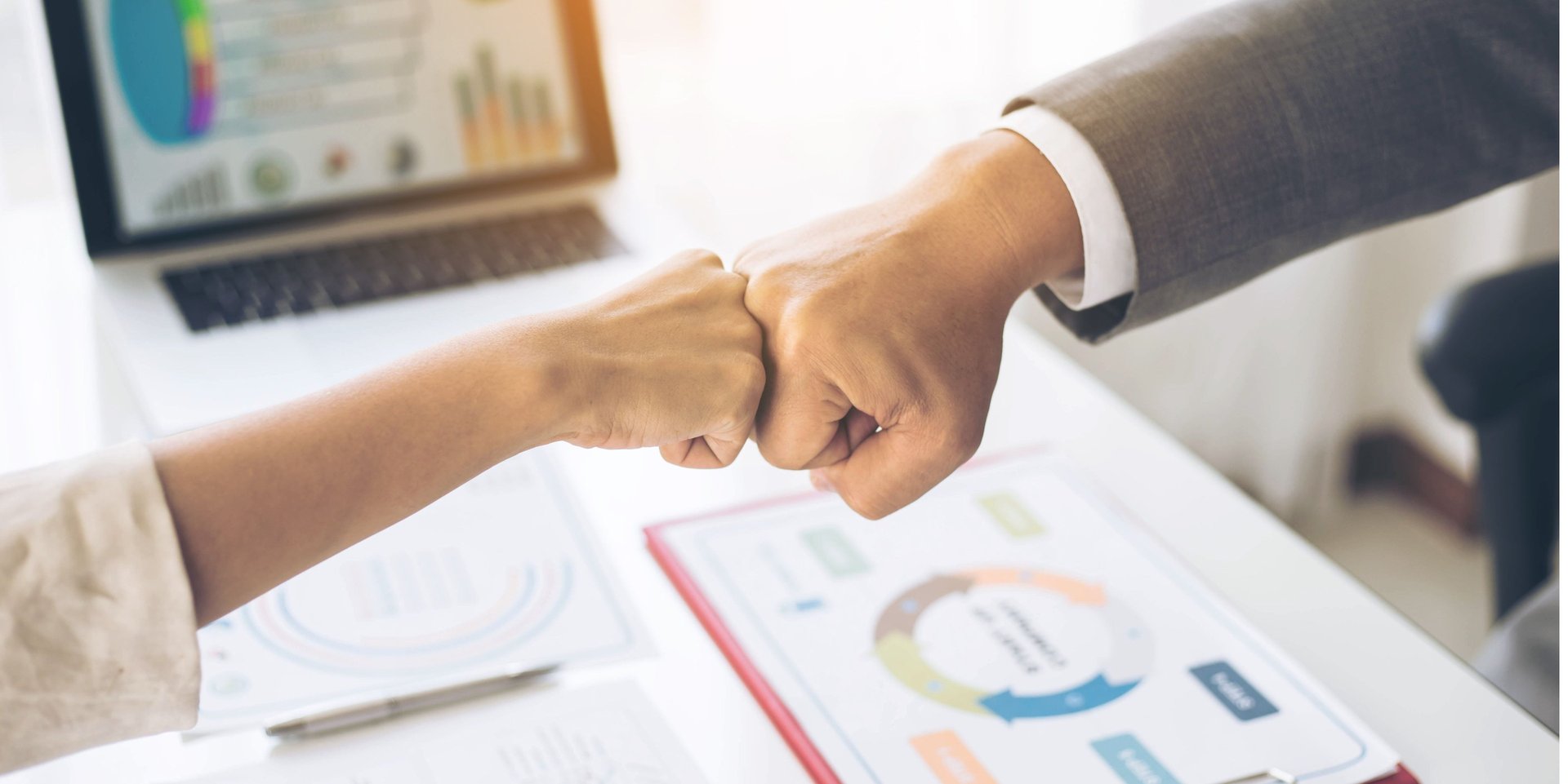 Un puño de un hombre y una mujer chocando en forma de trabajo en equipo