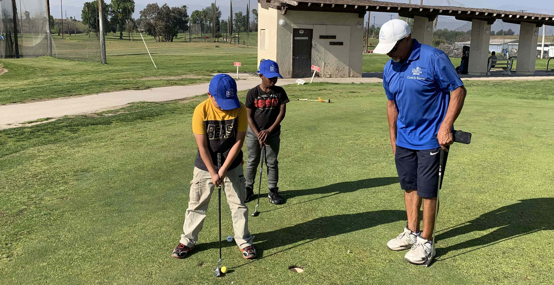 Enhancing Forward Action image of golf instructor teaching young students how to put