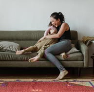 woman holding child and laughing