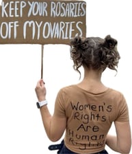 the creator protesting wearing a shirt that says women's rights are human rights and holding a sign