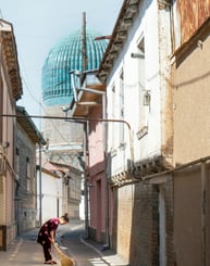 A girl is sweeping a narrow street in Tashkent