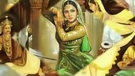 A woman in a green dress performs a dance, captivating an enlightened crowd with her graceful 