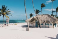 Beach hut on white sand with palm trees and turquoise water in Punta Cana, Dominican Republic