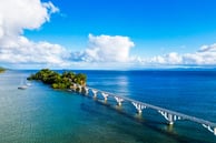 Samaná bridge over blue ocean with sailboats and tropical island in Dominican Republic