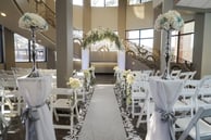 a wedding ceremony with white chairs and white chairs