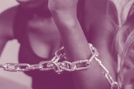 A black woman wearing shackles