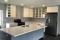 Two-tone RTA kitchen in Kelowna, navy base cabinets, white shaker uppers and a quartz island sinksin