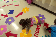 two children playing on a floor with bright flower images