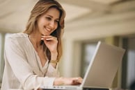 uma mulher sentada à mesa com um laptop
