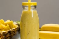a glass jar of lemonade with a strawberries and lemonade