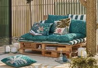 a couch with pillows and pillows on a patio