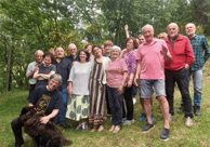 a group of people standing in a field with a dog