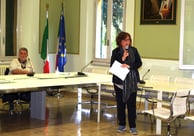 a woman standing in front of a table with a microphone