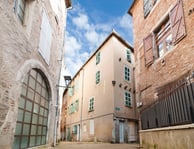 Vue grand angle de trois bâtiments anciens dans les ruelles étroites de Cahors, ciel bleu