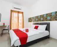 flazale reddoorz flash sale a bed with a red and white bedding and a television