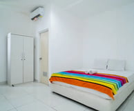 flazale reddoorz flash sale promo a bed with a colorful blanket and a white bed