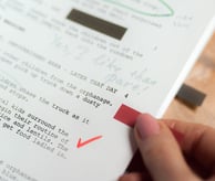 a person holding a piece of paper with a red arrow pointing to the left side