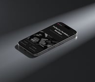 An iPhone displaying the YVZN website on its screen.