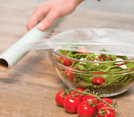 a person is holding a plastic container with tomatoes