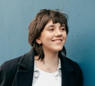 a woman with short hair and a purple jacket