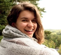 a woman in a sweater smiling