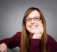 a woman with glasses and a purple sweater