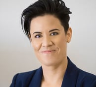 a woman with dark short hair and a blue blazer