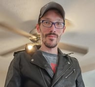 a man in a leather jacket and glasses