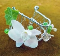 Brățară decorativă cu sârmă, orhidee albă, frunză de iederă și mărgele verzi.
