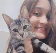 a woman holding a kitten in her arms