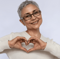 Middle aged woman making a heart with her hands.