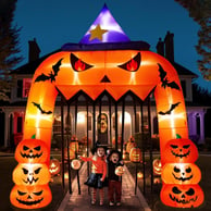 a couple of kids standing in front of a halloween themed archway