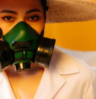 a woman in a white shirt and hat with a green mask