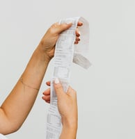 a woman holding a piece of paper with a receipt