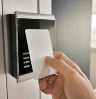 a person holding a card and pressing a button on a door
