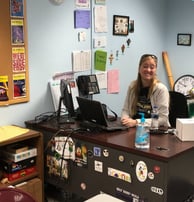 a teacher sitting at a desk in a classroom