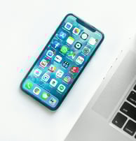 a cell phone and a laptop on a desk