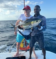 Angler showing off a caught Yellowfin Tuna on a catamaran - Catamaran Fishing Charters Seychelles