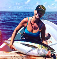 Woman proudly displaying a Yellowfin tuna during a Half-Day Fishing Charter in Zanzibar