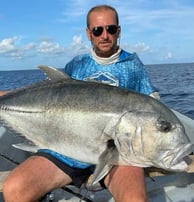 Angler holding a Giant Trevally after a successful Half-Day Fishing Charter in Zanzibar