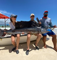 Excited anglers posing with a sailfish caught on a Half-Day Fishing Charter in Zanzibar