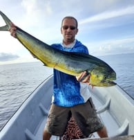 Excited fisherman with a freshly caught Dorado on a Full-Day Fishing Charter in Zanzibar