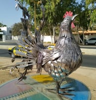 Sculpture métallique d’un coq grandeur nature, réalisée à partir de couverts recyclés