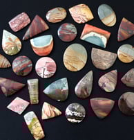 a large selection of hand cut scenic jasper cabochons in a variety of shapes