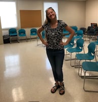 an educator standing in a classroom with a blackboard