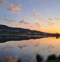 a lake with a bench and a bench in the foreground