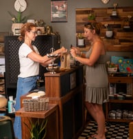 Cashier and a happy customer at the register of a boutique