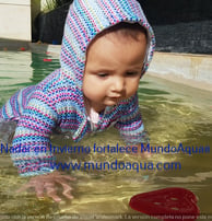 a baby in a pool with a frisbee in the water