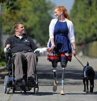 um homem em uma cadeira de rodas com um cachorro na coleira